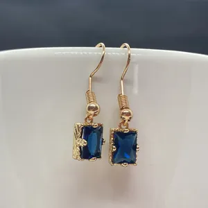 Vue détaillée de boucles d'oreilles en pierre bleue rectangulaire avec crochets dorés