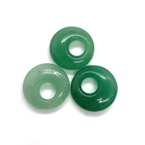 Detailed view of three polished natural green aventurine donut-shaped gemstone beads
