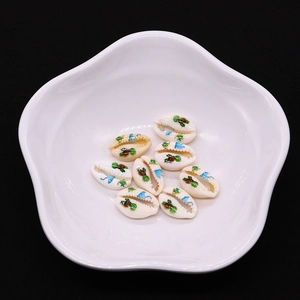 Detailed view of turtle-printed natural shell beads on a white porcelain dish