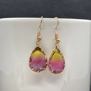 Close-up of teardrop natural stone crystal earrings with red and yellow gradients