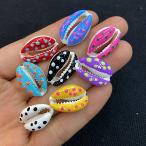 Macro shot of colorful dotted sea shell beads for DIY jewelry making held in hand