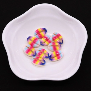 Dettaglio di 10 perle di conchiglia naturale arcobaleno su un piatto bianco decorativo