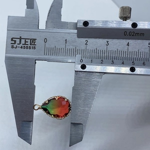 Detail view of teardrop faceted crystal pendant width measurement using digital caliper