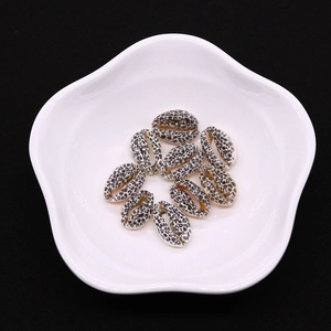 Makroansicht der Leopardenmuster-Naturmuscheln für DIY-Schmuck in einer weißen Schale