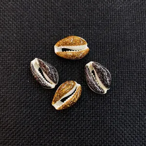 Close-up of DIY natural conch shell beads with gold and black glitter finish for jewelry