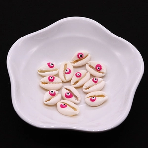 Dettaglio di perline di conchiglia con motivi a occhio rosa in una ciotola decorativa