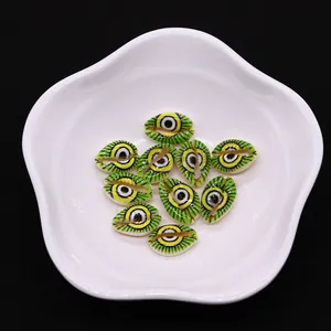 Detailed view of evil eye patterned natural shell beads on a white porcelain dish