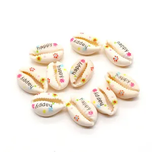 Detail of natural shells with colorful flower patterns and happy text for DIY jewelry