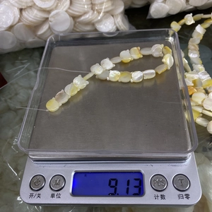 Cat-shaped shell beads weighing 9.13 grams on a digital scale for DIY jewelry