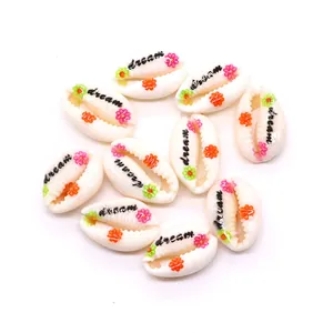 Macro shot of natural cowrie shells printed with dream text and colorful floral patterns