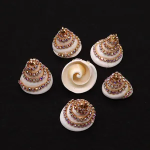 Macro-detail van spiraalvormige schelphangers met kleurrijke strass en gouden haken