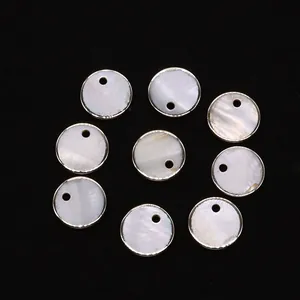 Détail de pendentifs ronds en nacre naturelle avec bordure argentée pour bijoux DIY