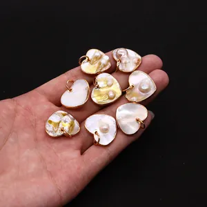 Dettaglio di un ciondolo in madreperla naturale a forma di cuore con placcatura oro