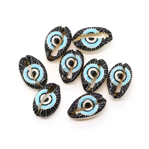Macro view of hand-painted evil eye shell beads for DIY necklace jewelry making