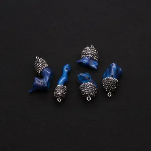 Detail von blauen Korallenanhängern mit schwarz kugelbesetzten Metallkappen