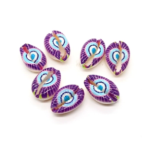 Macro detail of seven purple shell beads with blue eye patterns for DIY jewelry making