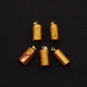 Detailed macro view of 5 synthetic coral cylinder pendants with golden connectors