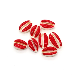 Dettaglio macro di conchiglie naturali con bordi smaltati in rosso per gioielli fai-da-te