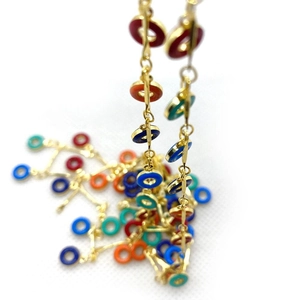 Detalle de anillos de esmalte de colores en cadena de metal dorado para crear joyas DIY
