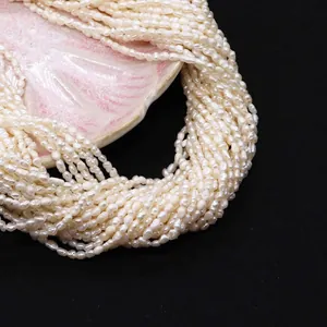 Close-up of natural freshwater seed pearls displayed on a pink shell ceramic tray