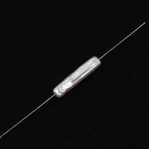 Dettaglio macro di una perla barocca rettangolare bianca naturale con lucentezza e foro
