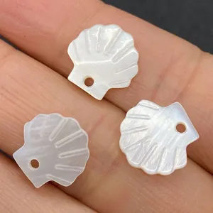 Macro shot of three natural shell scallop pendants with fine carved textures and hole