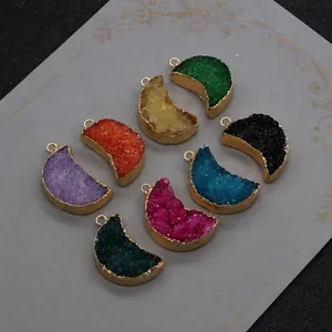 Détail macro de pendentifs en cristal en forme de lune avec bordure dorée colorée