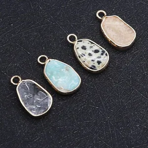 Detail of four irregular natural stone pendants with gold plating and hanging loops