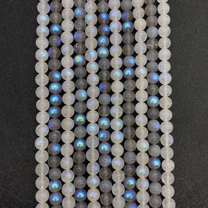 Detailed macro of labradorite beads with blue flash luster on black texture surface
