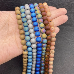 Detail of matte natural agate round beads in gold, blue, and silver for DIY jewelry