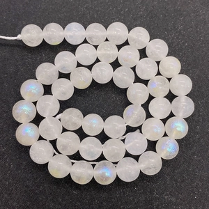 Macro shot of polished moonstone beads with blue flashes on a dark textured background