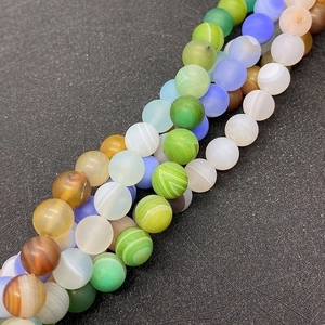 Macro shot of matte silk agate beads in multiple colors with natural striped textures
