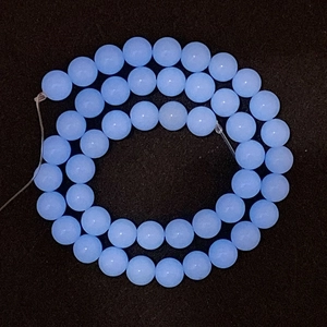 Macro shot of 8mm pale blue natural stone beads arranged in a double-ring spiral pattern