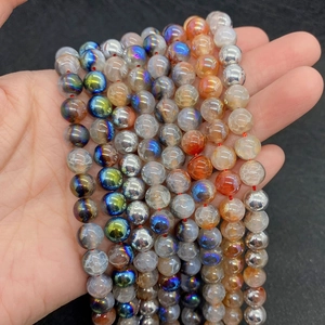 Close-up of hand holding colorful crackle agate beads with metallic finish for DIY jewelry