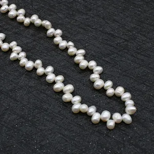 Macro shot of high-luster natural baroque freshwater pearls on textured dark gray surface
