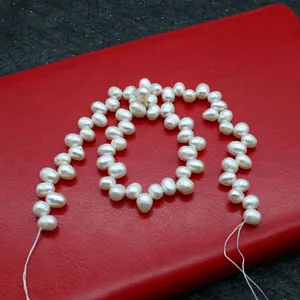 Detail of high-luster white freshwater pearls on a red surface showing natural textures