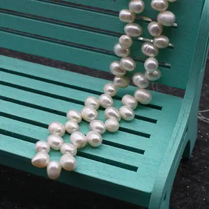 Macro shot of high-luster natural freshwater pearls on a miniature cyan wooden bench