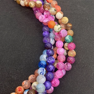 Macro-opname van gekleurde drakenader agaatkralen voor DIY-sieraden met unieke barstpatronen