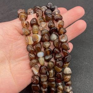 Détail macro de perles en agate naturelle irrégulière aux motifs rubanés pour bijoux