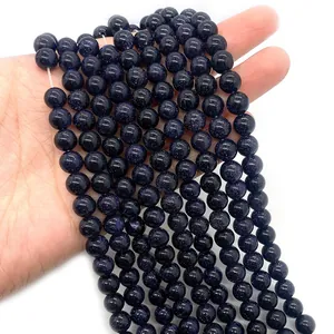Gros plan de perles en grès bleu de 6-8mm montrant une texture étincelante sur fond blanc