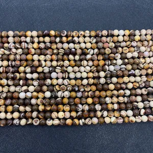 Détail macro des perles en jaspe zèbre avec textures naturelles et tons de terre uniques