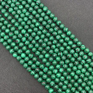 Dettaglio macro di perle tonde in malachite verde con trama naturale per gioielli fai da te