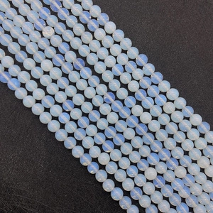 Macro shot of smooth translucent opalite beads with blue glow effect for DIY jewelry
