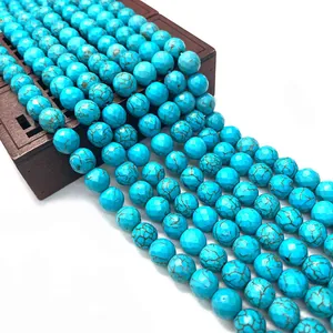 Facettierte natürliche blaue Türkisperlen auf einer Vintage-Holzbox für DIY-Schmuckherstellung