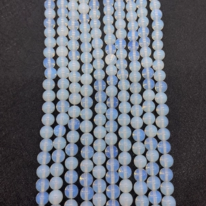 Macro view of smooth round opalite beads with blue sheen for DIY jewelry making