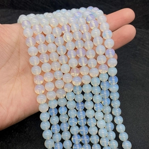 Detail of round semi-transparent opalite beads showing iridescent blue and yellow fire