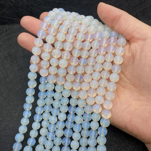 Detailed close-up of 8mm translucent opal beads for DIY bracelets held in hand