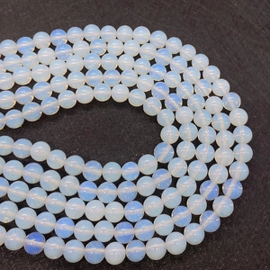 Close-up of translucent round opalite beads arranged in a spiral for DIY jewelry making