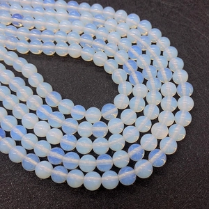 Macro shot of smooth round opal beads with soft blue sheen for DIY jewelry crafts