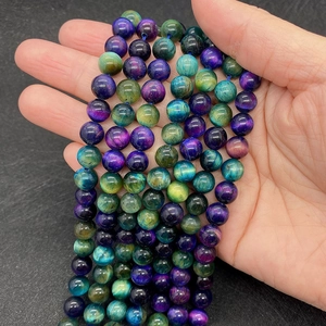 Macro shot of 8mm polished natural tiger eye beads in vibrant purple green and blue tones